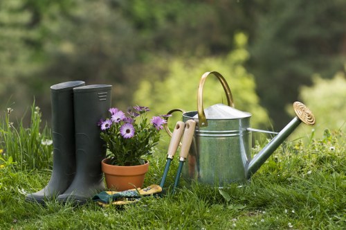 Gardener pruning shrubs in Millbank garden